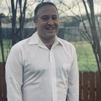 A man in white shirt smiling for the camera.